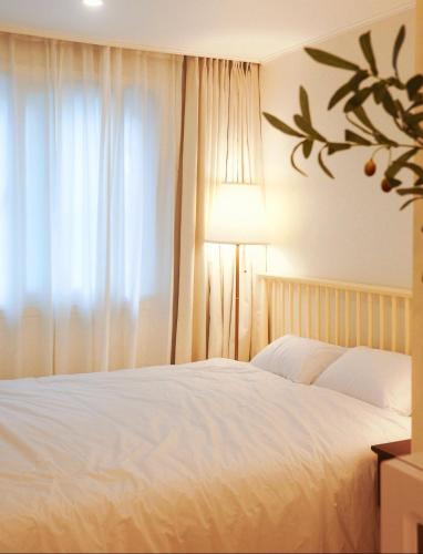 a bedroom with a white bed and a window at 홍대ㆍ공항철도 STAY h #올리모델링#홍대입구역 도보9분#연트럴파크3분#짐보관# 6인#호텔침구#각방에어컨#무료와이파이#세탁건조기#교통최고 in Seoul