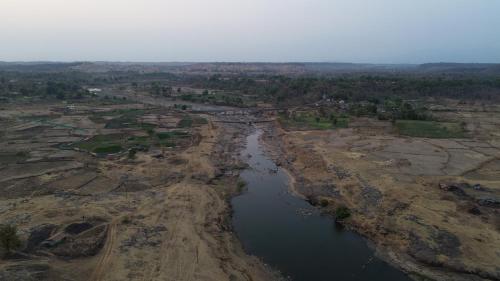 an aerial view of a river in a field at Nehamrit Farmstays with Pool, Near Malshej Ghat in Murbād