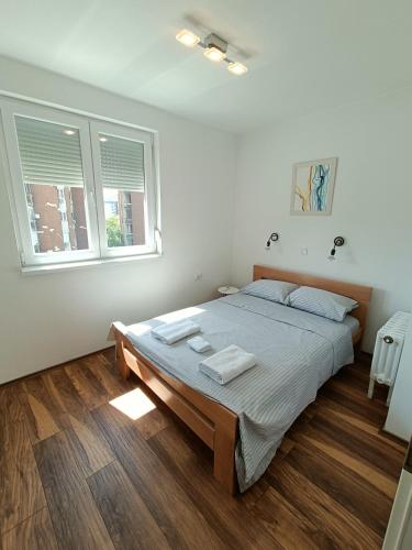 a bedroom with a large bed with two towels on it at Urban View - Main Square Gate Apartment in Skopje