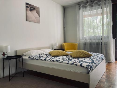 a bedroom with a bed with a window and a yellow chair at STUDIO APP STELLA Jarun Zagreb SELF-CHECK-IN in Zagreb