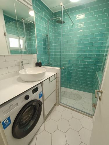 a bathroom with a washing machine and a sink at Urban View - Main Square Gate Apartment in Skopje