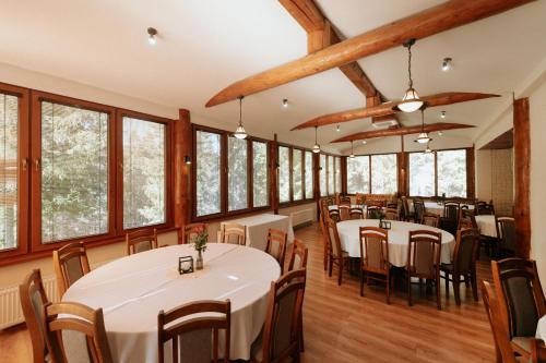 a dining room with tables and chairs and windows at Horský hotel Bartoška in Turčianske Teplice