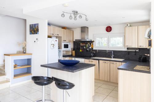 - une cuisine avec des placards blancs et un bol bleu sur le comptoir dans l'établissement La Belle Escapade - Climatisée aperçu mer, à Port-Vendres