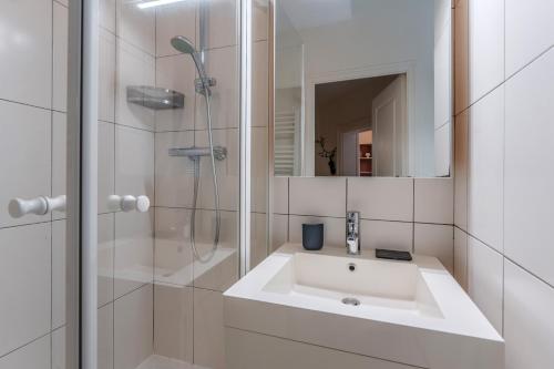 une salle de bain blanche avec un lavabo et une douche dans l'établissement Le Clemenceau - Cœur historique de Nantes, à Nantes