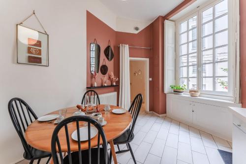 une salle à manger avec une table et des chaises en bois dans l'établissement Le Clemenceau - Cœur historique de Nantes, à Nantes