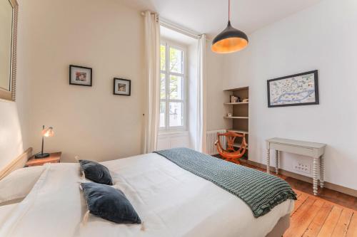 une chambre avec un grand lit blanc et une fenêtre dans l'établissement Le Clemenceau - Cœur historique de Nantes, à Nantes