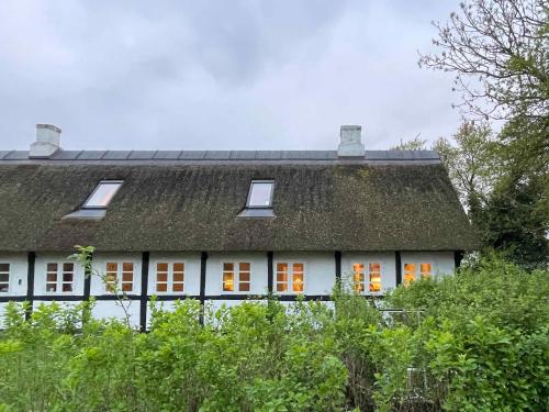 a white house with a roof with orange windows at Historic Summer House From 1877 With Scenic View in Stokkemarke
