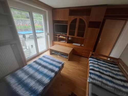 a living room with a couch and a tv and a table at Ferienwohnungen Wunderburg in Gmunden