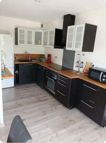 Il comprend une cuisine avec des placards noirs et blancs et du parquet. dans l'établissement Appartement quartier Beauregard à Rennes avec terrasse, à Rennes