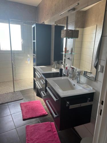 une salle de bain avec un lavabo et un grand miroir dans l'établissement Villa La Benoite à Carqueiranne, à Carqueiranne