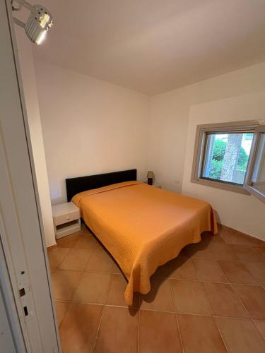 a bedroom with a bed with an orange bedspread at Wild Paradise in Costa Paradiso