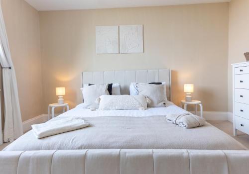 a bedroom with a large white bed with two lamps at Luxury Georgian Home, Nr the Lake District in Carnforth