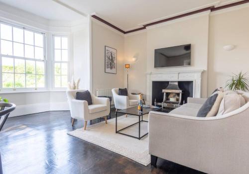 a living room with a couch and chairs and a fireplace at Luxury Georgian Home, Nr the Lake District in Carnforth