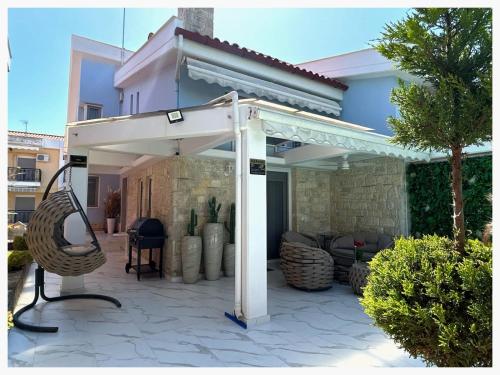 a white pergola in front of a house at villa MeDITeRAN in Pefkohori