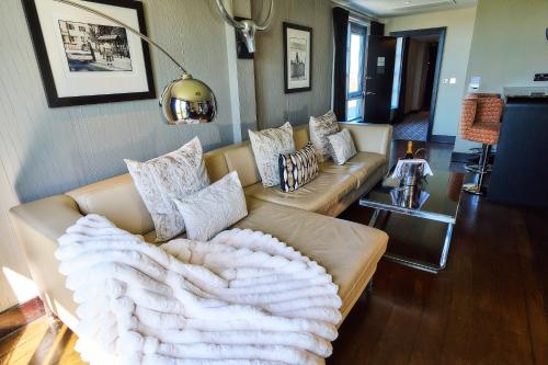 a living room with a couch with a blanket on it at The Vincent Hotel in Southport