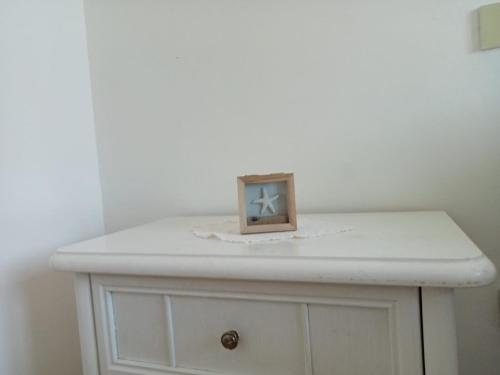 a white dresser with a picture on top of it at La casa di Franca in Formia