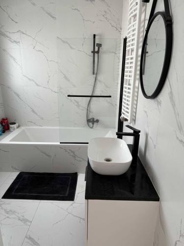 a bathroom with a tub and a sink and a mirror at Apartament 5 in Kobylniki