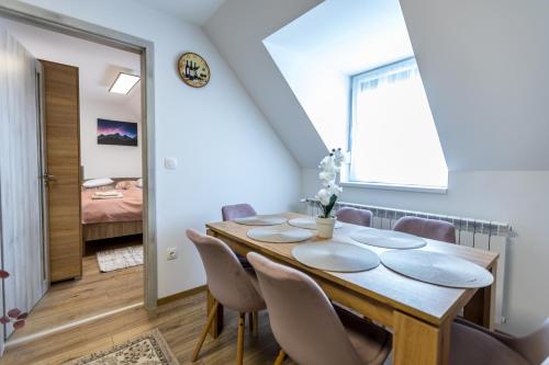 a dining room with a wooden table and chairs at Mátravölgy Apartmanház in Pásztó