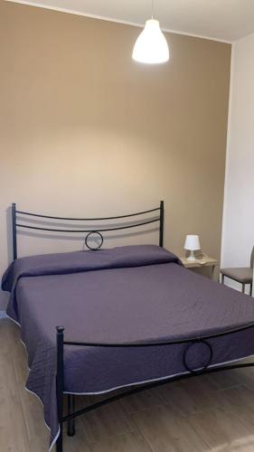 a bed with a purple comforter in a bedroom at Home Apollo in Giardini Naxos