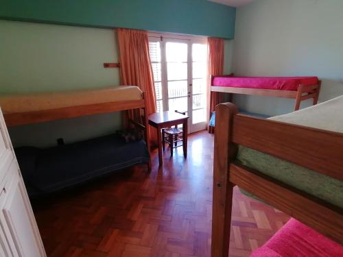 a room with two bunk beds and a table at Alamo Hostel & Suites in Mendoza