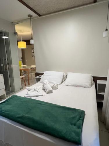 ein großes weißes Bett mit einer grünen Decke darauf in der Unterkunft Vg Sun Cumbuco in Cumbuco