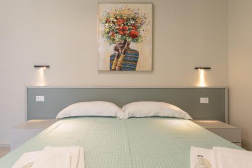 a bedroom with a bed with a painting on the wall at La Scala Suite in Realmonte