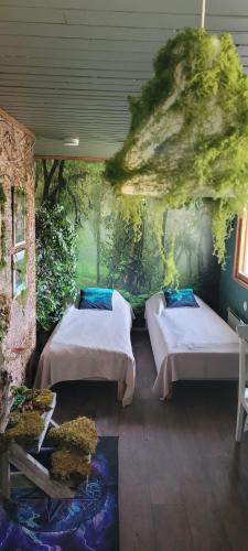 a bedroom with two beds and a fishtank in the floor at Elämysmajoitus Olipa Kerran in Turku