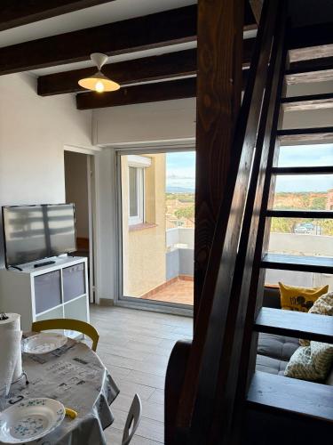 d'un salon avec une table et une porte coulissante en verre. dans l'établissement Appartement T3 pour 5 Personnes à 50 m de la plage PARKING PRIVE 5B2071B, au Barcarès