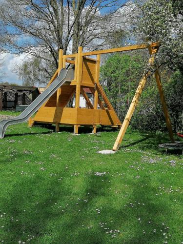 a playground with a slide in the grass at Landhaus Thätner Fewo 2 in Löbnitz