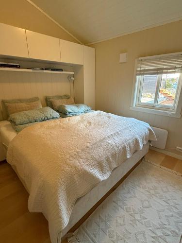 a bedroom with a large bed and a window at Welcome to Junibakken in Hofsøy