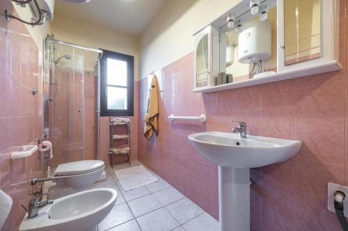 une salle de bain avec un lavabo et des toilettes dans l'établissement Via Delle Mimose 14, à Calasetta