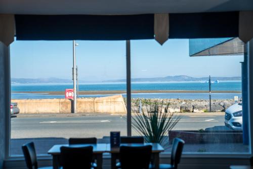 a restaurant with a view of the ocean from a window at The Strathmore Hotel in Morecambe