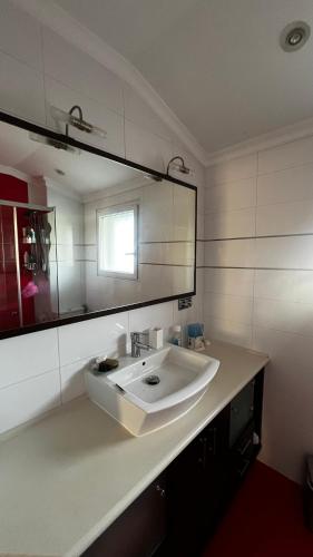 une salle de bain blanche avec un lavabo et un miroir dans l'établissement Villas del Emperador, à Hendaye