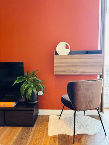 une chaise dans un salon avec un mur orange dans l'établissement Terracotta 7 Quiet and Private Parking, à Marseille