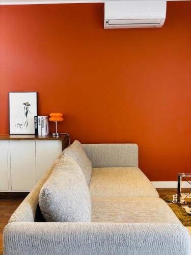 - un salon avec un canapé et un mur orange dans l'établissement Terracotta 7 Quiet and Private Parking, à Marseille