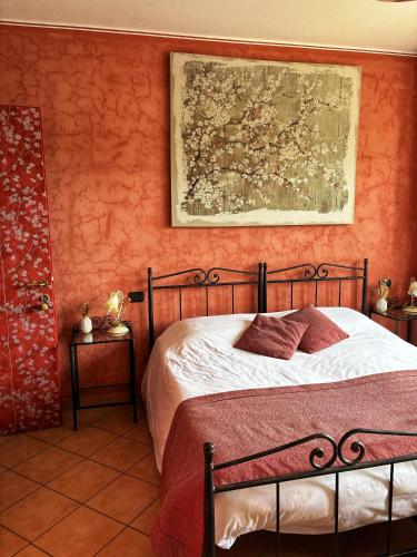 a bedroom with a bed and a painting on the wall at Agriturismo Tenuta San Giuseppe in Cossano Belbo