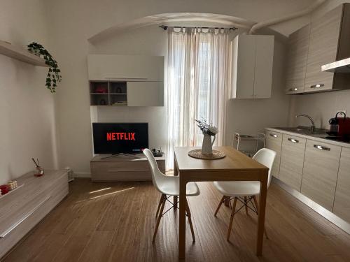 a kitchen with a table and white chairs and a table and a kitchen at Casa Rovani in Sesto San Giovanni
