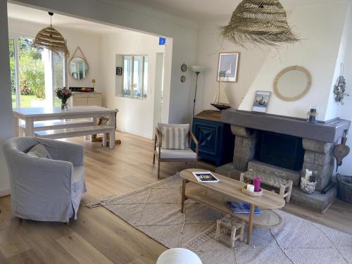 un salon avec une cheminée et une table dans l'établissement Villa bord de mer, à Mesquer