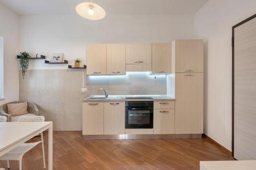 a kitchen with wooden cabinets and a sink and a table at Casa Vacanza Relais Sofia in Vico Equense