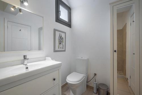 a white bathroom with a sink and a toilet at Tranquil house in Kipséli