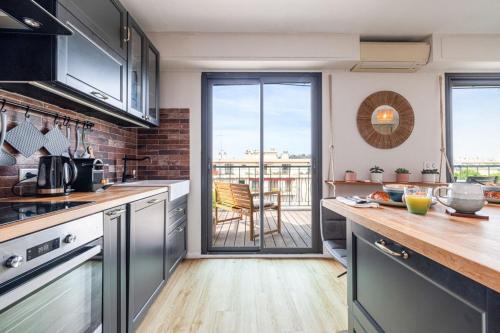 d'une cuisine avec des appareils en acier inoxydable et d'un balcon. dans l'établissement DELFINO - Charming roof terrace apartment w AC, à Nice