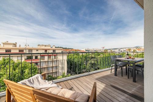 un balcon avec une table et une vue sur une ville dans l'établissement DELFINO - Charming roof terrace apartment w AC, à Nice