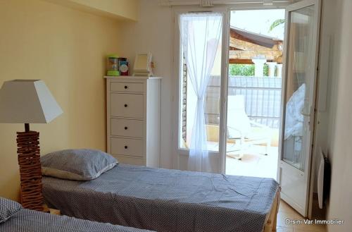 - une chambre avec un lit et une porte donnant sur une terrasse dans l'établissement charmant appartement calme à 400 m de la plage, à Saint-Raphaël
