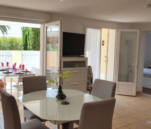 un salon avec une table et des chaises blanches dans l'établissement charmant appartement calme à 400 m de la plage, à Saint-Raphaël