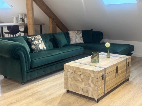 - un canapé vert et une table basse dans le salon dans l'établissement Firmin Gaillard, à Brive-la-Gaillarde