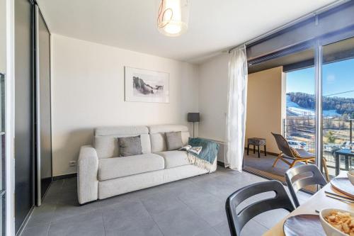 un salon avec un canapé et une table avec des chaises dans l'établissement Valberg - Magnificent studio terrace with parking, à Péone