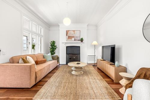 a living room with a couch and a tv at 2-4 Trinity Avenue in Sydney