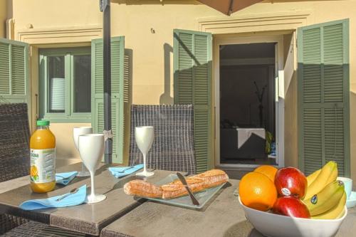 une table avec un bol de fruits et des verres à vin dans l'établissement JOFFRE 9 - Near Masséna Square - Terrace, à Nice