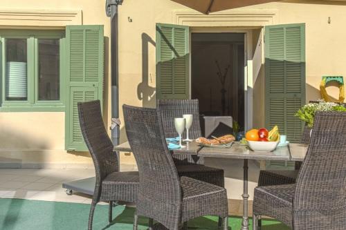 - une table avec des chaises et une corbeille de fruits sur la terrasse dans l'établissement JOFFRE 9 - Near Masséna Square - Terrace, à Nice