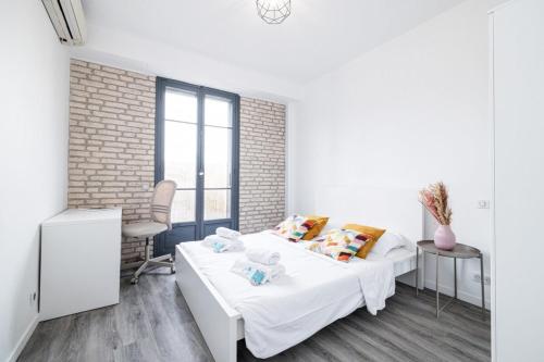 deux lits dans une chambre avec un mur de briques dans l'établissement OLIVETTO - Superb city center apartment with AC, à Nice